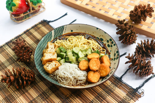 Rujak mie, a Palembang specialty, combines yellow egg noodles, fried tofu, pempek fish cakes, diced cucumber, rice vermicelli, and a tangy sweet-sour sauce called cuko.