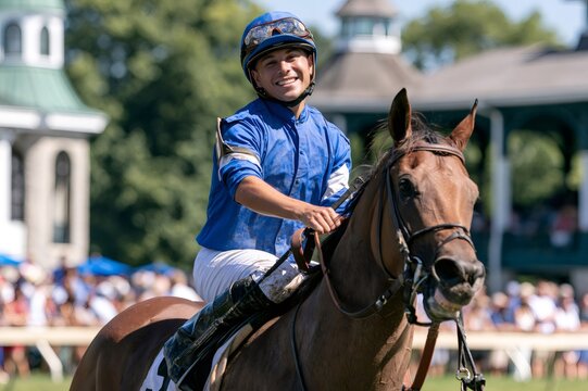 Jockey smiling riding racehorse after winning competition