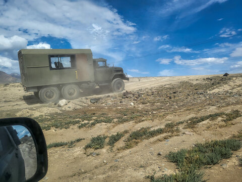 Green ZIL-131 6x6 off-road truck with a box body driving along a track in the mountainous landscape of the Altai region; Soviet off-road vehicle, Altai Republic, Russia 01.08.2025