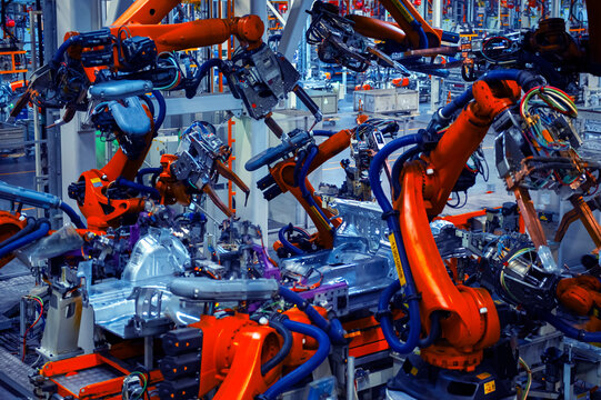 Industrial Robots Welding Car Body in Automotive Manufacturing Factory

