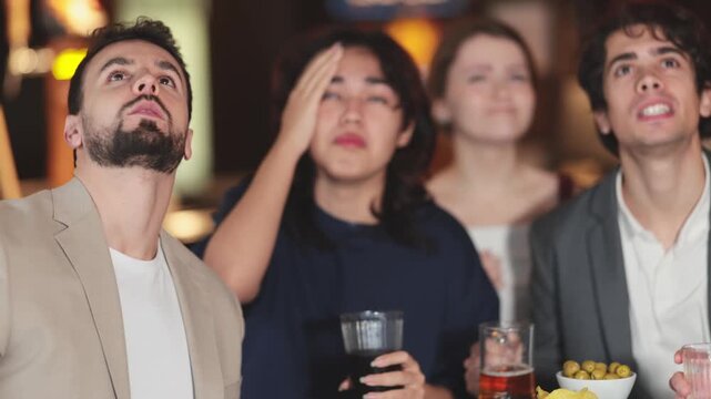 Friends meet at bar - disappointed fans watch on TV as their favorite team loses a match . High quality 4k footage