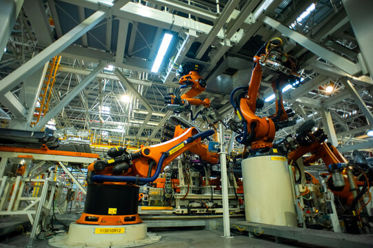 Industrial Robots Welding Car Body in Automotive Manufacturing Factory
