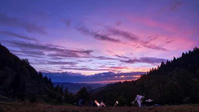 Timelapse of Dramatic Pink and Purple Sunset Transitioning to Dusk Over Mountain Village