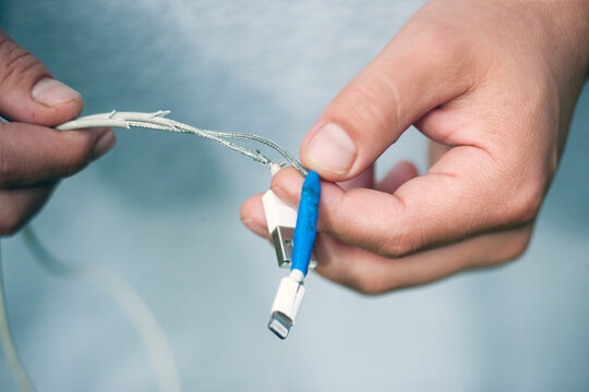 damaged charging cable in hands
