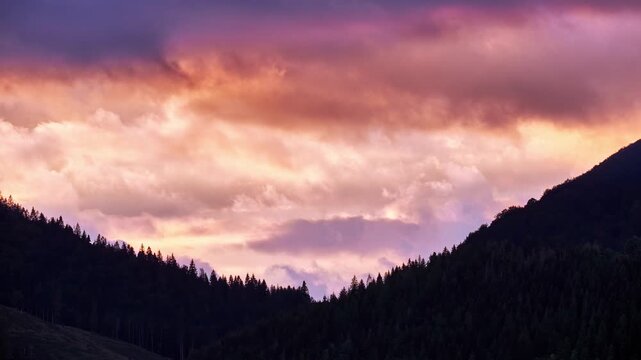 Telephoto Timelapse of Dramatic Sunset Clouds Between Forested Mountain Slopes