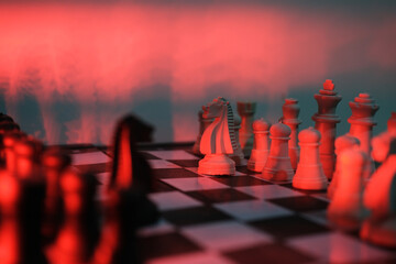 Close-up of a chess piece on a chessboard in dim red light. World Chess Day. International Chess Day. July 20.  © PANCASONA CREATION