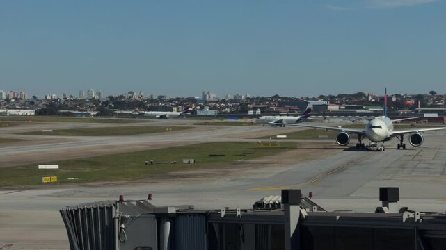 Wide Body Airplane Taxiing on Runway Framed by Airport Terminal