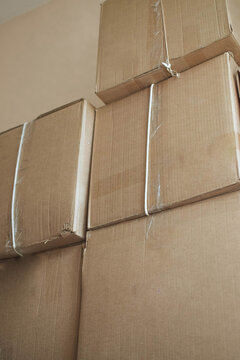 Tall stack of sealed cardboard boxes prepared for moving, illustrating packing, storage, transportation logistics and household or office relocation