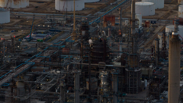 Aerial view of Fawley Refinery featuring complex industrial piping, tall processing towers, and large storage tanks under soft lighting in Southampton, England, United Kingdom.