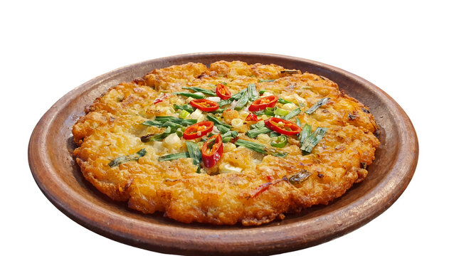 Korean mung bean pancake, crispy bindaetteok with chili and scallions, traditional savory pancake on clay plate, isolated asian food