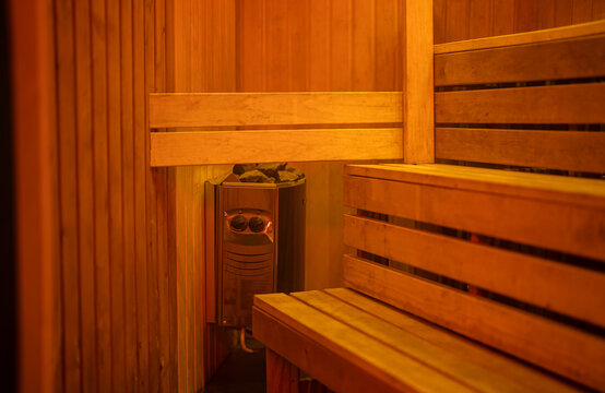 Wooden sauna interior with electric heater and benches.