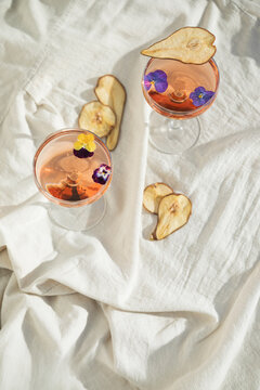 Two rose wine glasses on white fabric top view. Summer cocktails