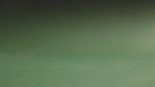 Close up of hand taking and putting back medicine bottle on green