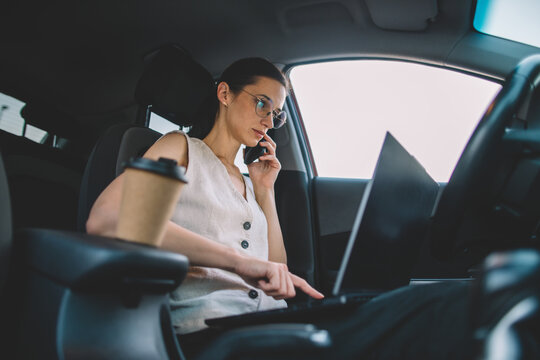 Businesswoman talking on phone and working in car