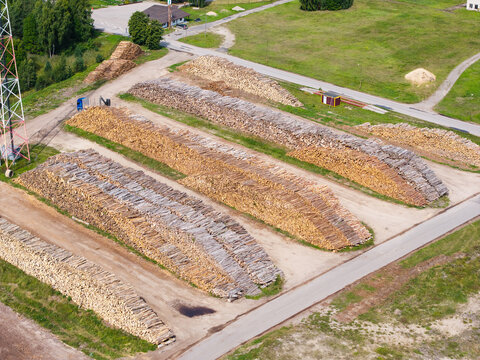 Aerial view of large timber commodity stockpiles arranged in neat rows at a port facility, showcasing raw material supply and the forest economy in Mersrags, Talsi Municipality, Latvia.