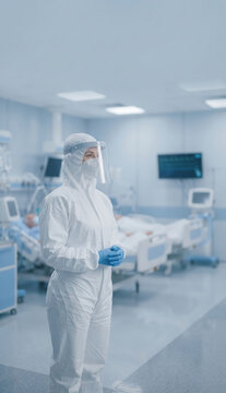 Healthcare worker in full protective suit standing in hospital intensive care unit