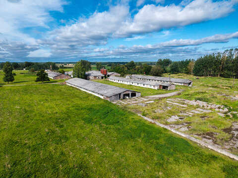 Aerial view of abandoned farm buildings and silos set in a rural landscape with green fields in Kulciems, Talsi Municipality, Latvia.