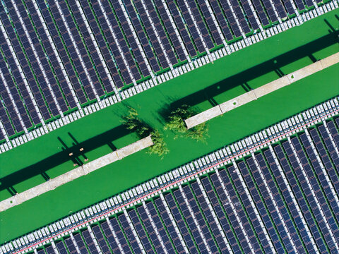 Aerial view of the Sloka wastewater treatment plant featuring rows of solar panels installed over green water basins with concrete walkways in Jurmala, Latvia.