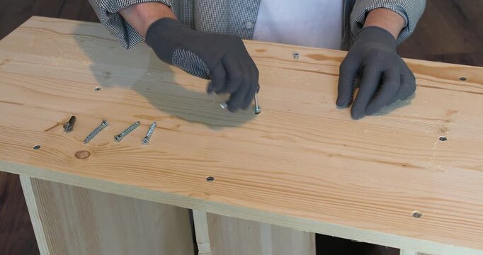 A carpenter assembling a wooden bookshelf