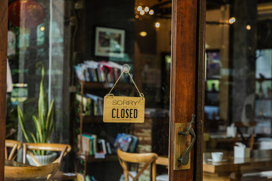 Portrait of young barista cafe owner standing at storefront with open sign, smiling confidently, representing independent entrepreneur lifestyle and sustainable small business startup growth concept