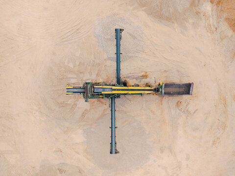 Aerial view of a gravel pit with industrial machinery and conveyor belts in Slampe parish, Tukums Municipality, Latvia.