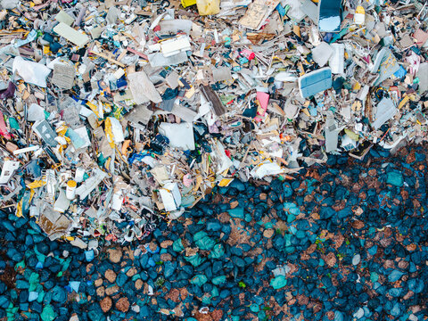 Aerial view of a waste management service site showing a large pile of mixed debris and sorted waste materials in Jurmala, Latvia.