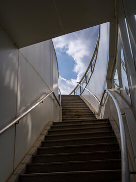 Low angle view of modern outdoor concrete stairs leading to blue sky