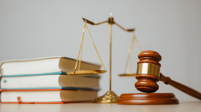 Law concept presents a wooden gavel, justice scales, and books, symbolizing legal authority, court procedure, regulation, and balanced rights for commercial use. Law firm, legal; law focus.