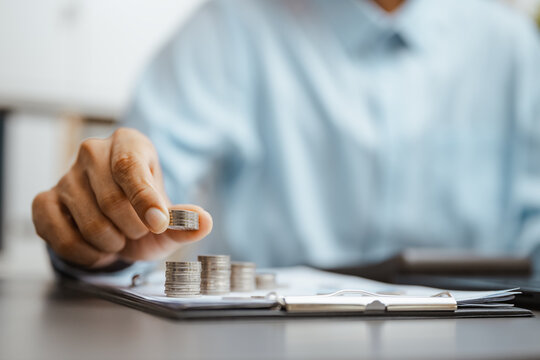 Budget calculation shows a hand placing a coin beside a calculator and clipboard, linking finance analysis, savings choices, and controlled. Investment analysis, financial; investment focus.
