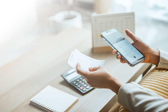 Budget review combines a smartphone, receipt, and calculator, representing digital finance tracking, savings discipline, and routine expenses for commercial use. Smart phone, receipt; smart focus.
