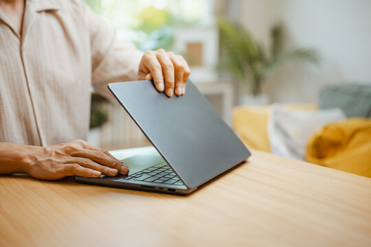 Laptop is opened by a person at a clean home desk, representing digital business access, modern technology, and a flexible workplace for commercial use. Using freelance, laptop; using focus.