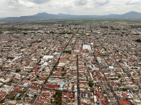 Aerial view of the dense urban landscape of Sahuayo with terracotta rooftops, narrow streets, and a prominent central church in Sahuayo, Michoacan, Mexico.