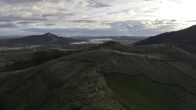 Aerial drone view of Chu Dang Ya Volcano at sunset in Bien Ho, Gia Lai, Vietnam, revealing dramatic volcanic terrain, lush highlands and a stunning golden sky.