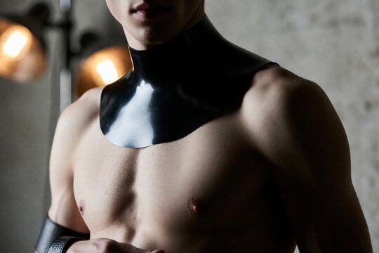 Shirtless man wearing black latex collar and wrist cuff