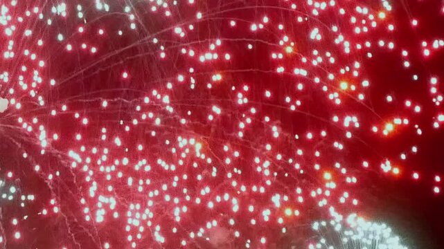 An ethereal dance of red, green, and orange lights explodes across the night canvas, a mesmerizing aerial ballet of fireworks. Celebrate with sparkling illuminations.