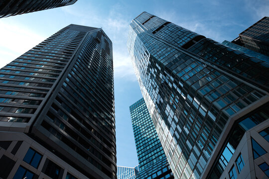 Cityscape, low angle view of skyscrapers in Frankfurt am Main. Residential and office buildings against a blue sky, modern architecture, building exterior.