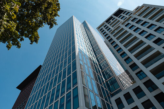 Modern architecture, cityscape, low angle view of skyscraper in Frankfurt am Main. Residential and office buildings against a blue sky, modern architecture, building exterior.