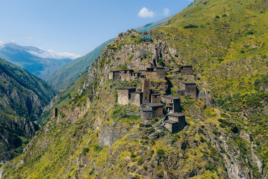 Aerial view of the medieval village of Mutso, featuring ancient stone towers and houses perched on a rocky mountain ridge in the Caucasus Mountains, Mutso, Mtskheta-Mtianeti, Georgia.