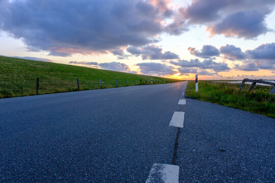 Tramonto sulla strada costiera e parco naturale sul Mare del Nord nei pressi di Dageb&uuml;ll, Germania