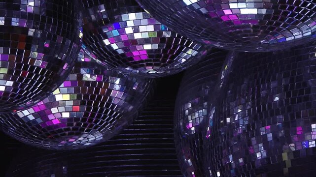 A dazzling array of mirror balls casts shifting patterns of emerald green, ruby red, and sapphire blue.