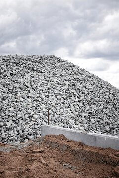 Pile of gravel at construction site with cloudy sky in the background during daylight hours