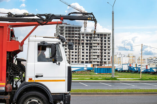 Construction truck transporting materials near a developing building site in an urban area