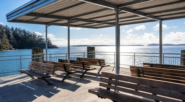 Covered outdoor waiting area with wooden benches overlooking the calm ocean.