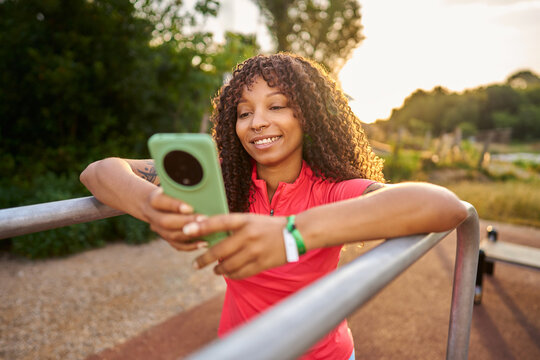 Young black woman using smartphone in park