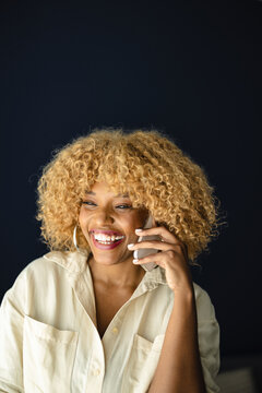 Woman Talks On The Phone While Smiling Indoors