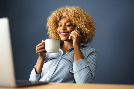 Woman Talking on the Phone While Enjoying Coffee at Home