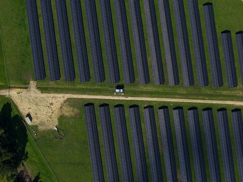 Aerial view of The Basin Solar Panels Melbourne featuring rows of photovoltaic modules installed on green grass fields under clear daylight The Basin, Victoria, Australia.