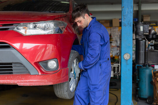 Mechanic changing wheel at the garage