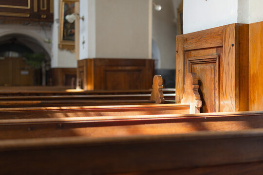 Empty catholic church with wooden benches and altar in view during a religious ceremony.