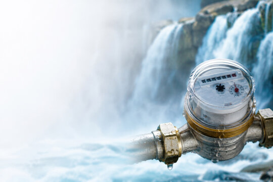 Water meter on a pipe appears before a large waterfall. Space for text.